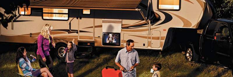 RV Fifth Wheel and Pickup Truck with Family Enjoying the Outdoors.